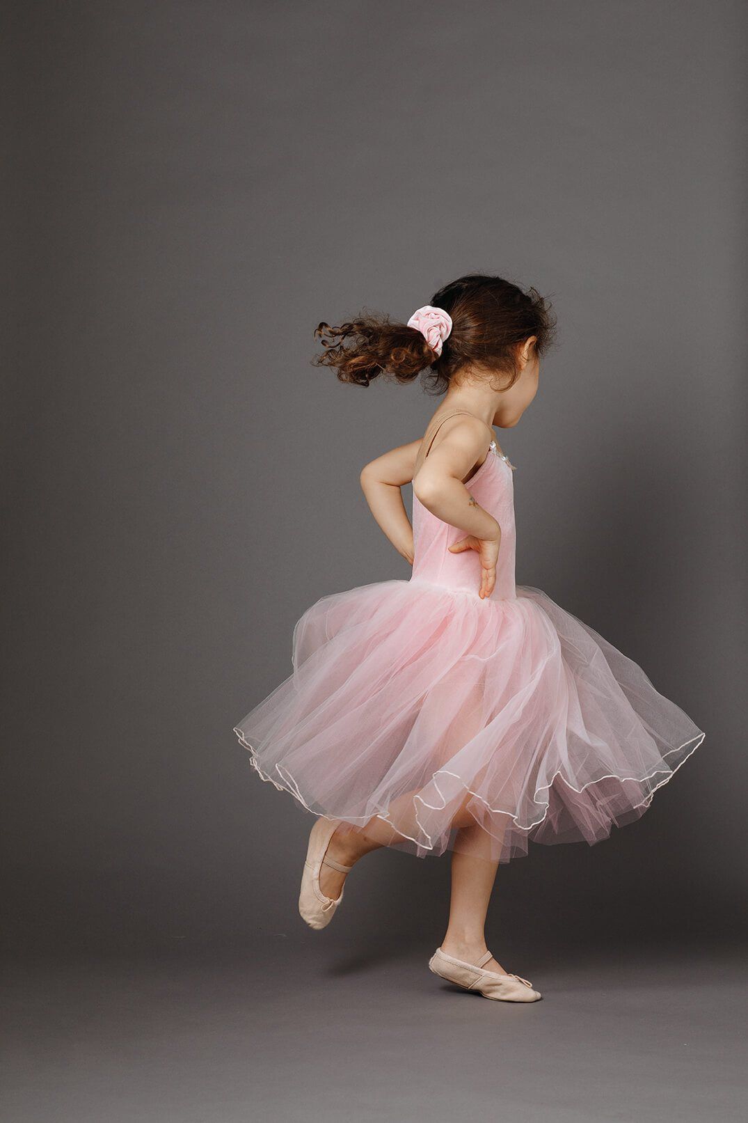 A girl in a pink tutu mid-twirl