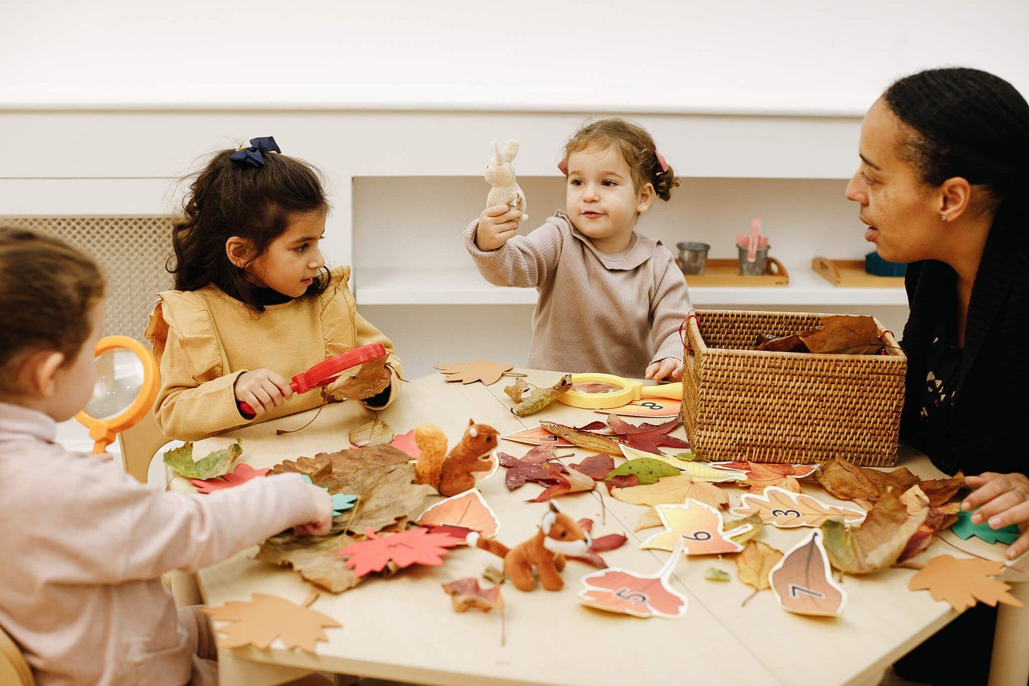 Children exploring autumn leaves with magnifying glasses